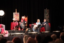 w aulii Regionalnego Centrum Oświatowo-Sportowego na scenie siedzi w fotelu Magdalena Sokołowska-Gawrońska a obo niej na sofie siedzą prowadzący Benefisscenie aulii 