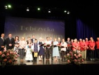Zdjęcie grupowe wszytskich laureatów Nagrody Burmistrza stojących na scenie