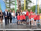 Grupa przedszkolaków na scenie otrzymujących nagrodę.