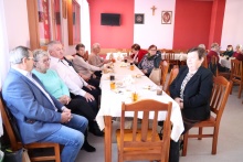 członkowie koła emerytów i rencistów siedzą przy stole podczas tradycyjnego spotkania przy herbatce 