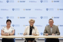 „Przy stole siedzą trzy osoby podczas podpisania umowy o dofinansowanie. Pośrodku wicewojewoda małopolska Elżbieta Achinger, po prawej burmistrz Dobczyc Tomasz Suś, a po lewej główna księgowa Renata Banowska. W tle znajduje się ścianka z logotypami Wojewody Małopolskiego, Ministerstwa Spraw Wewnętrznych i Administracji oraz programu Ochrona ludności i obrona cywilna.”