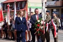 burmistrz Tomasz Suś wraz z wiceburmistrz Edutą Podmokły składa wiązankę pod Grobem Nieznanego Żołnieża w tle poczty sztandarowe