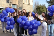 młodzież stojąca przed szkołą podstawową w rękach mają pęki balonów
