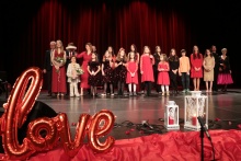 grupa dzieci w czerwonych strojach na dużej scenie 