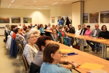 Na zdjęciu uczestnicy spotkania siedzący w ławkach