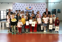 Grupa dzieci z burmistrzem Tomaszem Susiem oraz dyrektorem MGOKiS Andrzejem Topą z dyplomami i nagrodami podczas uroczystości w MGOKiS Dobczyce.