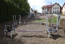 mini park linowy zamontowany na placu zabaw w tle budynek szkoły podstawowej w Brzączowicach 