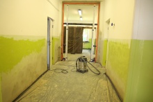 korytarz w szkole podstawowej w kolorze ścian zielony, montowane są też drzwi przeciwpożarowe