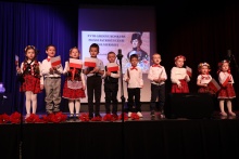 Grupka dzieci występujących na scenie podczas Konkursu. Niektóre z nich mają flagi polski w dłoniach.