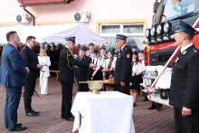 Komendant Powiatowy Państwowej Straży Pożarnej przekazuje naczelnikowi OSP Nowa Wieś klucze w towarzystwie burmistrza oraz wojewody