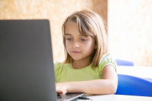 dziewczynka siedząca przy laptopie