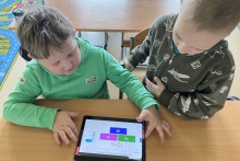 Dwójka chłopców korzysta z tableta interaktywnego.