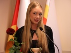 Laureatka nagrody burmistrza w dziedzinie sportu Julia Sadkiewicz stoi przy mównicy i przekawia w ręku trzyma czerwoną różę 