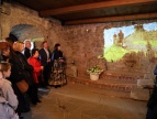 uczestnicy uroczystości stoją w sali dobczyckiego zamku i oglądają projekcję wyświetlaną na kamiennych ścianach komnaty