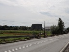 droga, po obu stronach pas zieleni, z lewej strony widok na remontowany chodnik