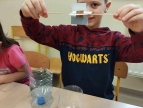 chłopiec prezentuje skonstruowaną turbinę wodną