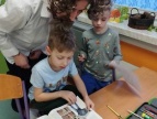 nauczyciel edukuje uczniów pokazując im materiały w książce 