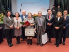 grupa ludzi w eleganckich strojach fotografują się wspólnie na gali 