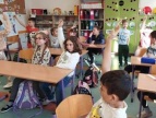 grupa dzieci w sali lekcyjnej siedzący w ławkach 