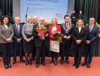 grupa ludzi w eleganckich strojach fotografują się wspólnie na gali 