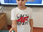 chłopiec pokazuje w dłoni  ulepioną z plasteliny kulę ziemską