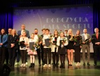 na scenie stoją w dwóch rzędach przedstawiciele samorządu wraz z laureatami Nagrody Burmistrza w dziedzinie sportu
