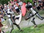 dwóch rycerzy walczą ze sobą w tle widać obserwujących walkę