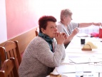 członkowie koła emerytów i rencistów siedzą przy stole podczas tradycyjnego spotkania przy herbatce 