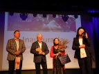 Czwórka osób ubranych w eleganckie stroje podczas inauguracji na dużej scenie 