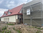 Biały budynek filli biblioteki publicznej z dobudowaną cześcią po prawej stronie