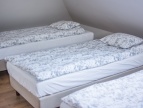 3 łóżka z białą pościelą
