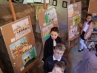 widok na galerię z pracami nadesłanymi na konkurs, dzieci chodzą i oglądają galerię