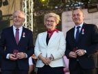Od lewej: Marek Gabzdyl, wicewojewoda Elżbieta Achinger oraz burmistrz Gminy i Miasta Dobczyce Tomasz Suś podczas uroczystości wręczenia odznaczeń w czasie Dni Dobczyc. Marek Gabzdyl i Tomasz Suś prezentują otrzymane medale oraz etui z odznaczeniami.