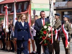 burmistrz Tomasz Suś wraz z wiceburmistrz Edutą Podmokły składa wiązankę pod Grobem Nieznanego Żołnieża w tle poczty sztandarowe