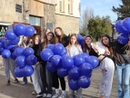 młodzież stojąca przed szkołą podstawową w rękach mają pęki balonów