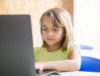 dziewczynka siedząca przy laptopie