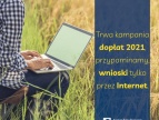 osoba siedząca na łące z komputerem i napis: trwa kampania dopłaty 2021, wnioski tylko przez internet