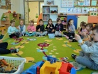 dzieci z muzycznymi bransoletami siedzące na dywanie