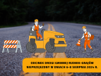 droga na której stoi maszyna budowlana obok robotnicy układają słupki blokujące wjazd