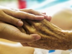zdjęcie - dwie ręce osoby młodszej i starszej w opiekuńczym geście