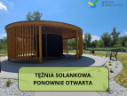 zdjęcie tężni solankowej w Parku Miejskim na dole prostokąt w którym na zielonym tle jest napis: tężnia solankowa ponownie otwarta