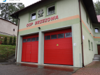 budynek OSP Brzezowa od frontu z 2 szt drzwi garażowych w kolorze czerwonym nad drzwiami napis OSP Brzezowa 