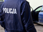 Plany działań priorytetowych na okres od 01.08.2026r do 31.01.2027r. Policjant stojący przy radiowozie, na kurtce widoczny napis „POLICJA"