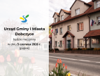 Grafika informująca o zamknięciu Urzędu Gminy i Miasta Dobczyce. Po lewej stronie znajduje się jasne tło z logo Dobczyc oraz tekstem: „Urząd Gminy i Miasta Dobczyce będzie nieczynny w dniu 5 czerwca 2026 r. (piątek)”. Po prawej stronie widoczny jest budynek urzędu z flagami Polski i Unii Europejskiej oraz kwiatami na pierwszym planie.