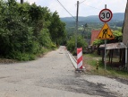 Droga aswaltowa, a z prawej strony ustawiony znak z 30 km/h. Pod nim znak ostrzegawczy o remontach pra wykonywanych na danym odcinku drogi