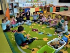 dzieci z muzycznymi bransoletami siedzące na dywanie
