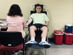 na fotelu siedzi mężczyzna oddający krew obok niego przedstawiciel Regionalnego Centrum Krwiodawstwa i Krwiolecznictwa