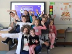grupa dzieci pod tablicą multimedialną