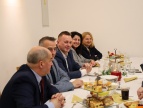 grupa osób siedząca przy stoliku ubrana w eleganckie stroje