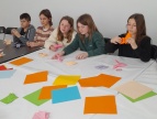 Uczniowie wykonują origami z kolorowych kartek.